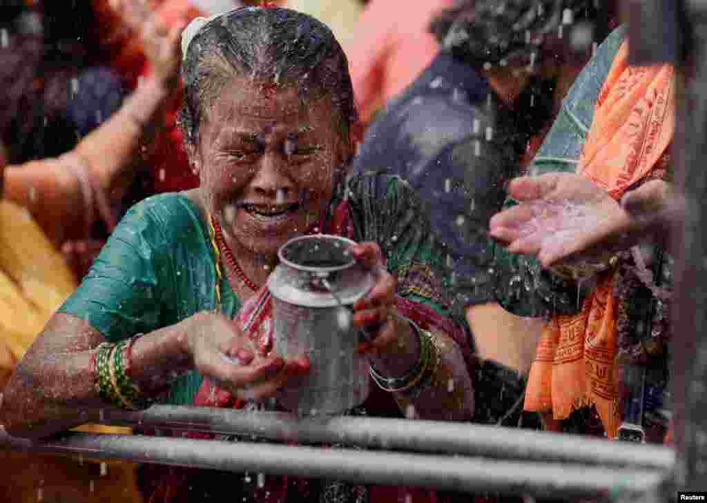 A devotee collects &quot;Panchamrit,&quot; a mixture of milk, water, yoghurt, jaggery and honey, at Makhan Pashupatinath temple during the Shrawan Sombar festival in Kathmandu, Nepal.