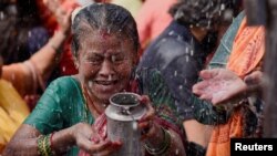 A devotee collects &quot;Panchamrit,&quot; a mixture of milk, water, yogurt, jaggery and honey, at Makhan Pashupatinath temple during the Shrawan Sombar festival in Kathmandu, Nepal.