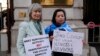 FILE - Helena Kennedy, left, and Rahima Mahmut hold placards as activists protest at the British Foreign Office in London, Feb. 13, 2023. They were demanding a meeting with the foreign secretary to highlight concerns for compatriots in China's Xinjiang Uyghur Autonomous Region.