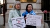 FILE - Human rights campaigners Helena Kennedy, left, and Rahima Mahmut hold placards as activists protest outside the British Foreign Office in London, Feb. 13, 2023. 