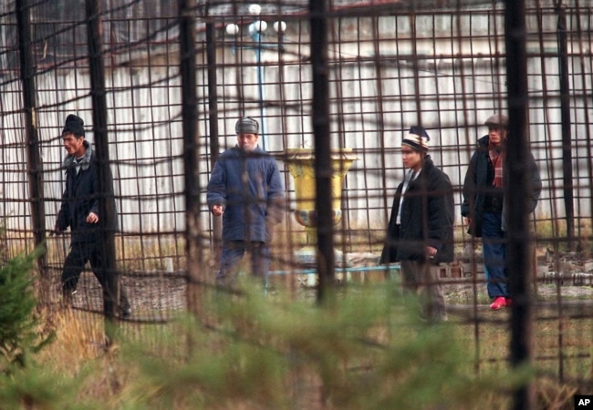 FILE - Prisoners walk inside Corrective Labor Colony No. 22 in the village of Leplei, some 600 kilometers southeast of Moscow, on Nov. 13, 1996. (AP Photo/Alexander Zemlianichenko, File)