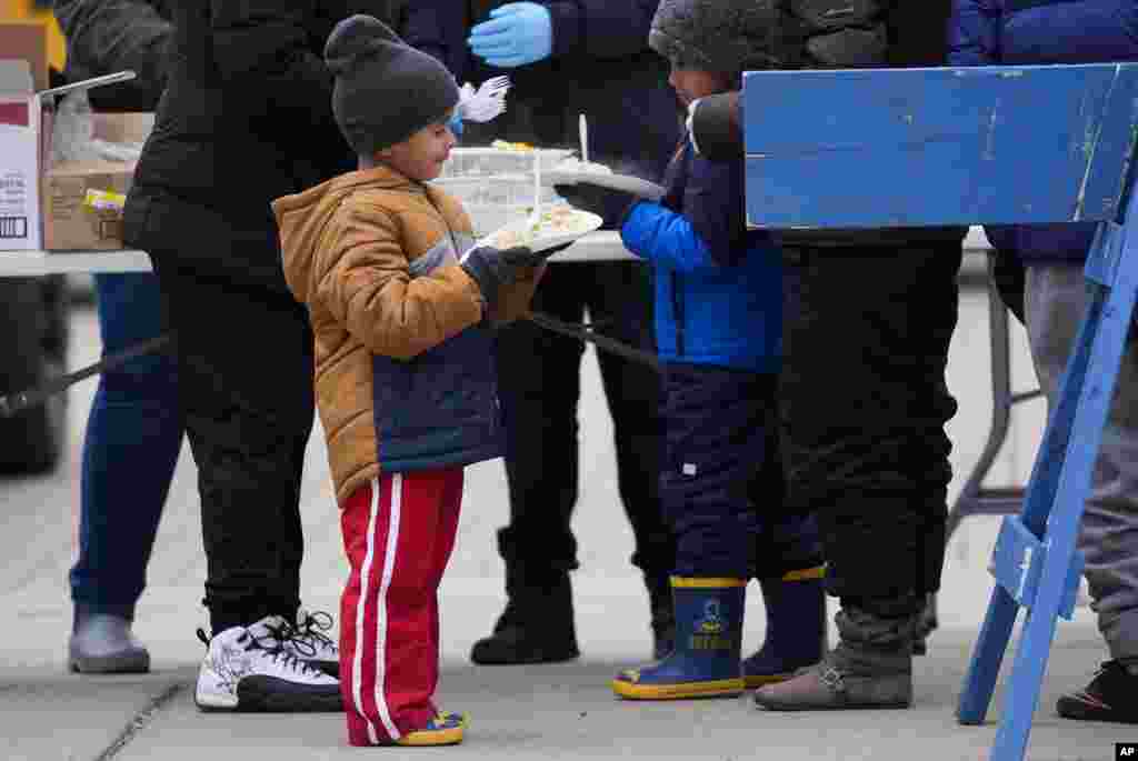 Un niño migrante recibe alimentos de Chi-Care.