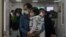 FILE - A man with a child walks out from a crowded holding room of a children's hospital in Beijing on Oct. 30, 2023.