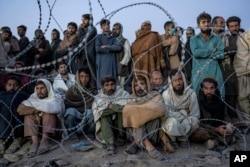 FILE - Afghan refugees wait to register in a camp near the Torkham Pakistan-Afghanistan border in Torkham, Afghanistan, Nov. 4, 2023.