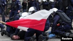 Police officers restrain a demonstrator during a farmers' protest against the European Union's Green Deal and imports of Ukrainian agricultural products, in Warsaw, Poland, March 6, 2024. 