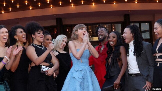 Taylor Swift, along with dancers and the band, attends a premiere for Taylor Swift: The Eras Tour in Los Angeles, California, Oct. 11, 2023.