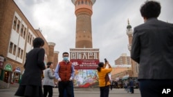 FILE - Tourists are seen in Urumqi, Xinjiang Uyghur Autonomous Region, April 21, 2021. Some U.S. lawmakers are demanding that seafood processed in two Chinese provinces be banned from entering the U.S. market on the grounds of rights abuse.