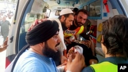 First responders move a wounded man into an ambulance after a bomb explosion in the Bajaur district of Khyber Pakhtunkhwa, Pakistan, July 30, 2023. (Rescue 1122 Headquarters via AP)