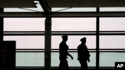 FILE - Polisi berpatroli di terminal keberangkatan di bandara Munich, Jerman, Minggu, 26 Maret 2023. (AP/Matthias Schrader)