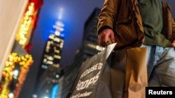 FILE - A man carries his shopping bags in New York City, Dec. 10, 2023. 