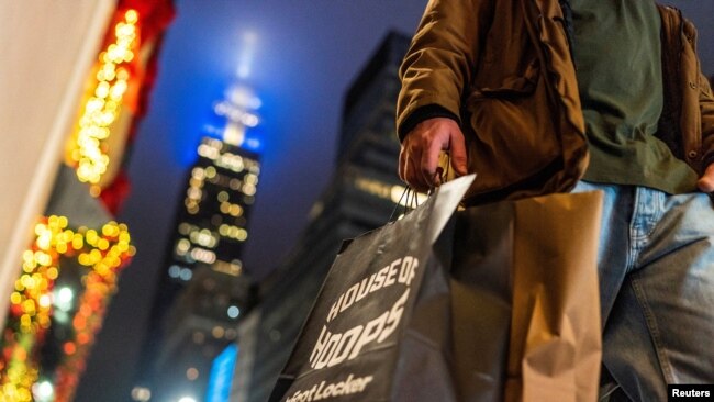 FILE - A man carries his shopping bags in New York City, Dec. 10, 2023.