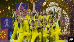 Australian players celebrate with the trophy after winning against India during the ICC Men's Cricket World Cup final match in Ahmedabad, India, Nov.19, 2023.