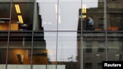 FILE -- A worker sits at his desk in an office building in Washington.