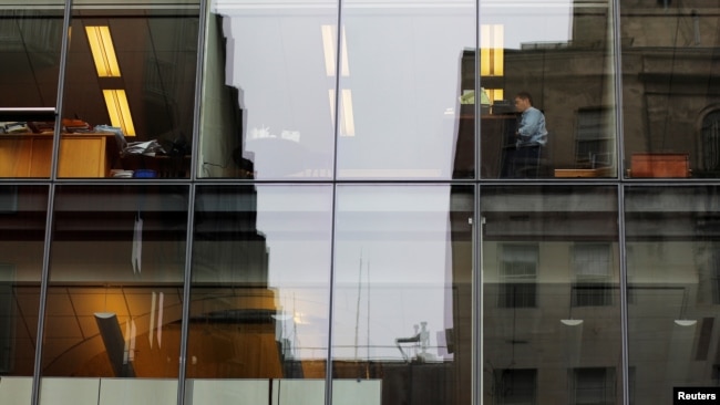 FILE -- A worker sits at his desk in an office building in Washington.
