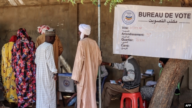 FILE - People wait to cast their votes during a constitutional referendum at a polling station in N'Djamena, Chad, Dec. 17, 2023. The country's electoral commission has set May 6, 2024, for a presidential poll.