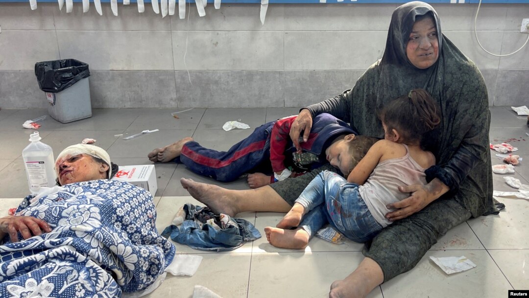  اکتوبر 2023 کو غزہ شہر کے شفا ہسپتال میں ایک فلسطینی خاتون اپنے بچوں کو سنبھالے ہوئے ہے، جو اس کے ساتھ اسرائیلی حملے میں زخمی ہوئے تھے فوٹو رائٹرز 23 اکتوبر 2023