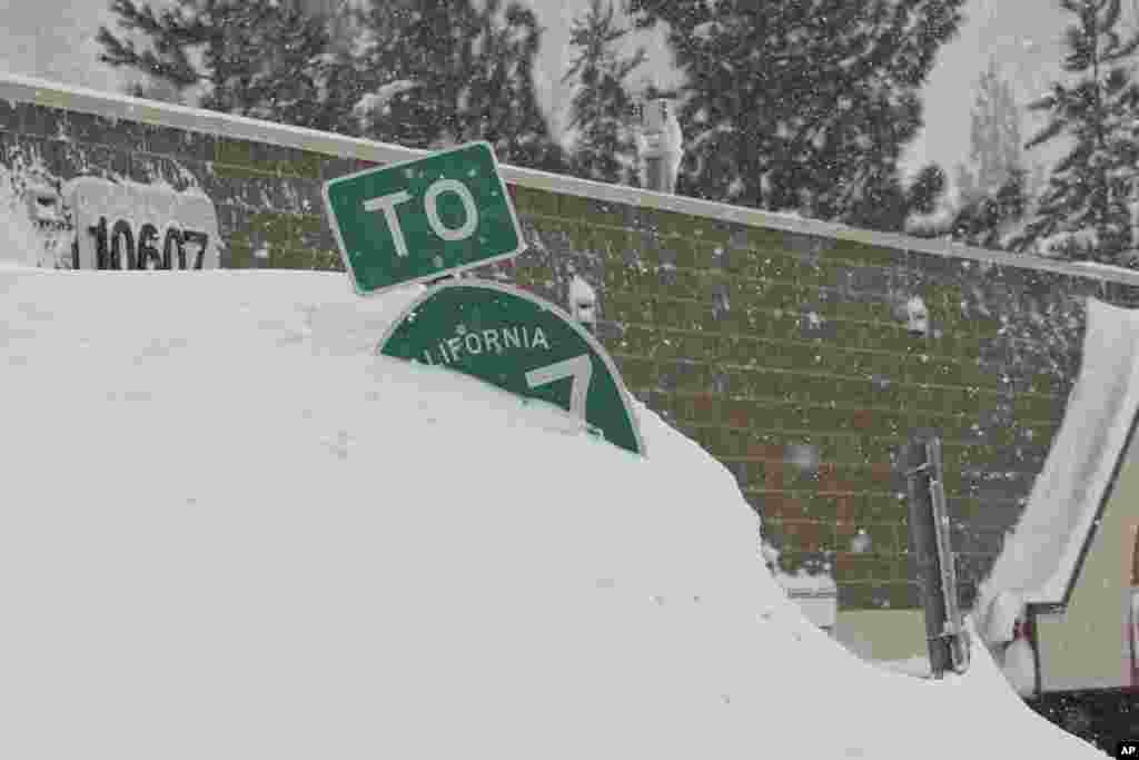 Una señal de carretera cubierta de nieve durante la tormenta, Truckee, California.