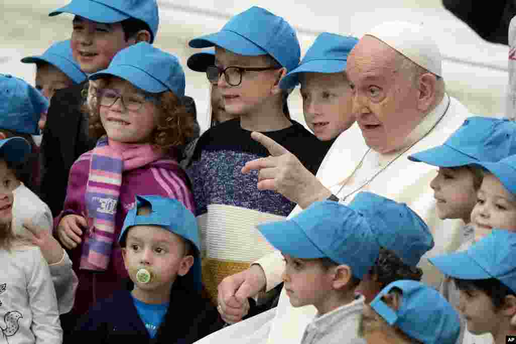Папата Фрањо се фотографира деца за време на неговата неделна аудиенција во салата Папа Павле VI во Ватикан.