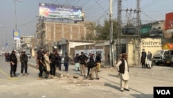 Police and onlookers are seen gathered at the site of a blast in Peshawar, Pakistan, Dec. 5, 2023. (Usman Khan/VOA Deewa Service)