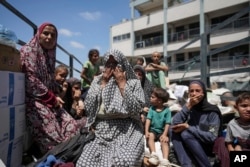 Seorang wanita Palestina menangis di truk saat dievakuasi dari sekolah tempat berlindungnya di Deir al-Balah, Jalur Gaza, setelah militer Israel mengedarkan selebaran evakuasi.