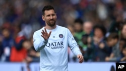 Lionel Messi memberi isyarat saat melakukan pemanasan sebelum pertandingan sepak bola Liga Satu Prancis antara Paris Saint-Germain dan Lorient, di stadion Parc des Princes di Paris, Minggu, 30 April 2023. (Foto: AP)