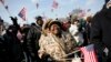 File—An African woman waves a U.S. flag at the National Mall during the inauguration of President Barack Obama, Washington, Jan. 20, 2009