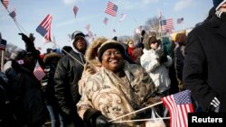 File—An African woman waves a U.S. flag at the National Mall during the inauguration of President Barack Obama, Washington, Jan. 20, 2009