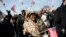 File—An African woman waves a U.S. flag at the National Mall during the inauguration of President Barack Obama, Washington, Jan. 20, 2009