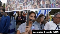 Una mujer con las manoa atadas y la boca amordazada participa en la marcha por el regreso de los rehenes en poder de Hamás que hoy concluyó ne Jerusalén, muy cerca de las oficinas del Primer Ministro, Benjamín Netanyahu.