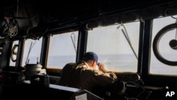 FILE - A crew member observes from the bridge of the USS Gravely destroyer in the south Red Sea, Feb. 13, 2024. Greek-flagged oil tanker traveling through the Red Sea came under repeated attack Wednesday, the British military said.