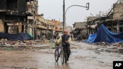 A Palestinian walks in Gaza City on Monday, Nov. 27, 2023. on the fourth day of the temporary ceasefire between Hamas and Israel. (AP Photo/Mohammed Hajjar)