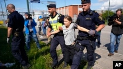 Aktivis iklim Greta Thunberg dibawa paksa oleh dua orang polisi saat aksi protes memblokir pintu masuk fasilitas minyak di kota Malmo, Swedia, 24 Juli 2023.