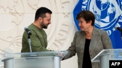 Ukrainian President Volodymyr Zelenskyy shakes hands with International Monetary Fund Director Kristalina Georgieva following talks at IMF headquarters in Washington, Dec. 11, 2023.