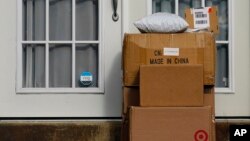 FILE - Packages are seen stacked on the doorstep of a residence, Oct. 27, 2021, in Upper Darby, Pa.