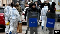 Turski službenici forenzičke policije drže kutije dok se kreću ispred crkve Santa Maria nakon napada, u Istanbulu, 28. januara 2024.