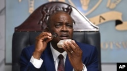 Presiden Botswana Mokgweetsi Masisi memegang berlian seberat 2.492 karat yang digali di salah satu tambangnya dan akan dipamerkan di Gaborone, Kamis, 22 Agustus 2024. (Foto AP)