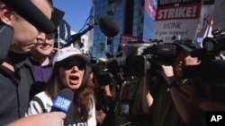 SAG-AFTRA president Fran Drescher, left, speaks with reporters as she takes part in a rally by striking writers and actors outside Netflix studio in Los Angeles, July 14, 2023.