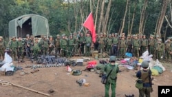 Members of the Myanmar National Democratic Alliance Army are pictured with weapons allegedly seized from the Myanmar's army outpost on a hill in Chinshwehaw town, Oct. 28, 2023.
