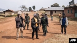Des hommes armés du Codeco marchent avec leur chef à Linga, en Ituri, le 13 janvier