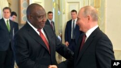 FILE: Russian President Vladimir Putin, right, shakes hands with South African President Cyril Ramaphosa during a meeting with a delegation of African leaders and senior officials in St. Petersburg, Russia, on Sat. June 17, 2023. 