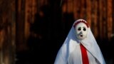 A reveler, dressed in a costume symbolizing death, walks through the village of Lidecko during a traditional Saint Nicholas parade near the town of Vsetin, Czech Republic, Dec. 4, 2023. 