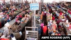 Pessoas fazem compras num mercado em Luanda, Angola, em 19 de janeiro de 2018. (Photo by AMPE ROGERIO / AFP)