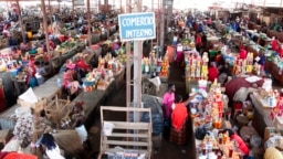 Pessoas fazem compras num mercado em Luanda, Angola, em 19 de janeiro de 2018. (Photo by AMPE ROGERIO / AFP)