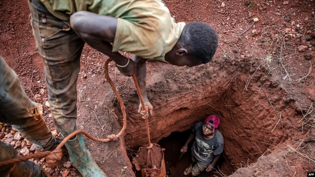 FILE - Tanzanian miners extract soil to look for gold at an open-pit gold mine in Nyarugusu, Geita Region, May 27, 2022.