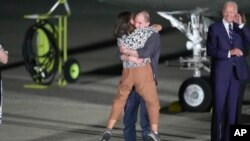 El reportero Evan Gershkovich abraza a su madre, Ella Milman, mientras el presidente Joe Biden observa en la Base de la Fuerza Aérea Andrews, Maryland, luego de su liberación como parte de un intercambio de prisioneros entre Rusia y Estados Unidos, el 1 de agosto de 2024.