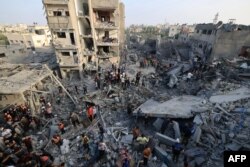 Orang-orang memeriksa kerusakan akibat serangan Israel di kamp pengungsi Al-Maghazi di Deir Balah di Jalur Gaza tengah, pada 5 November 2023. (Foto: AFP)