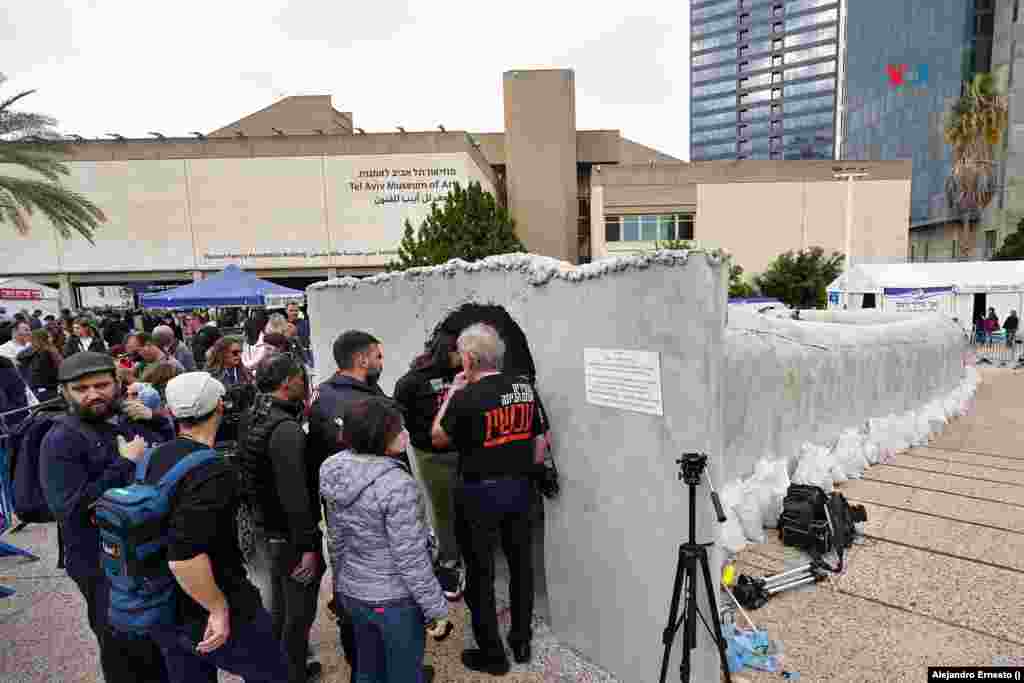 Periodistas y público hacen cola para entrar en la réplica de un túnel de Hamás, emplazada en la Plaza de los Secuestrados, en Tel Aviv.