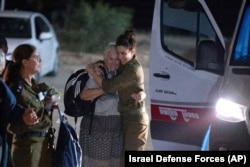 Margalit Mozes, a released Israeli hostage, walks with an Israeli soldier shortly after her arrival in Israel, Nov. 24, 2023.