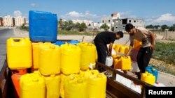 Warga Palestina mengumpulkan air bersih di tengah kekurangan pasokan air minum di Khan Younis, di bagian selatan Jalur Gaza, di tengah konflik Israel-Palestina yang masih berlangsung, Minggu, 15 Oktober 2023. (Foto: Ibraheem Abu Mustafa/Reuters)