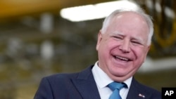 FILE - Minnesota Governor Tim Walz laughs during a visit to the Cummins Power Generation Facility in Fridley, Minn., April 3, 2023.